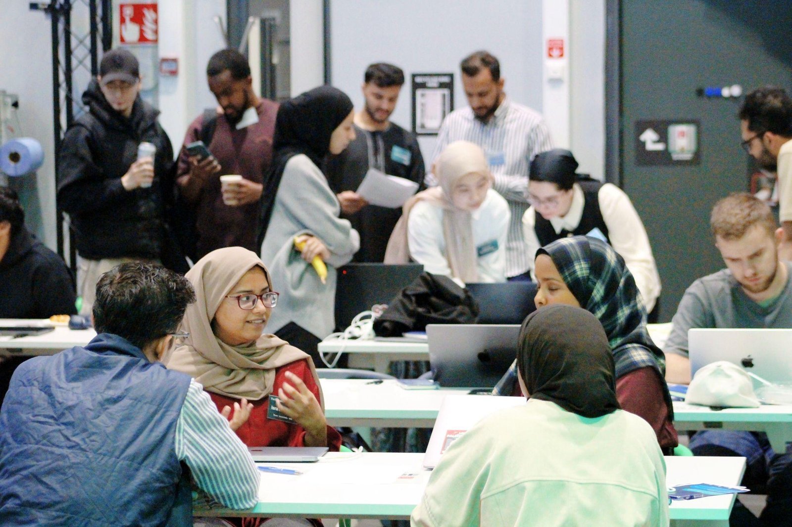 Participants discussing ideas and working together during the Diwan Hackathon